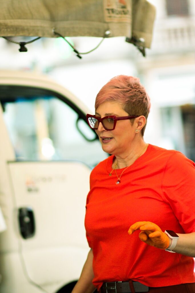 a woman in a red shirt is holding a piece of food