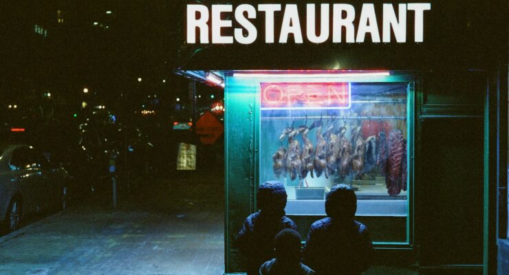 People admire the food display in a restaurant window.