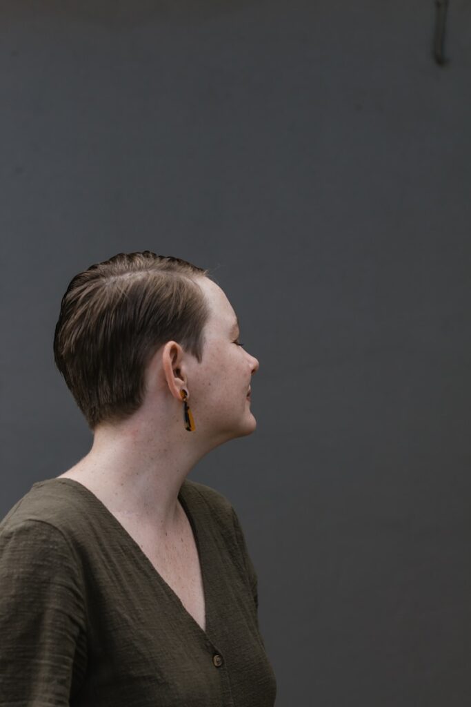 woman in gray shirt with silver earring