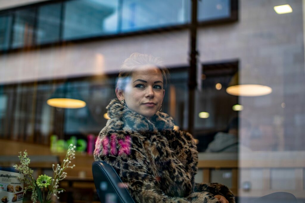 view of a sitting woman from a clear glass window