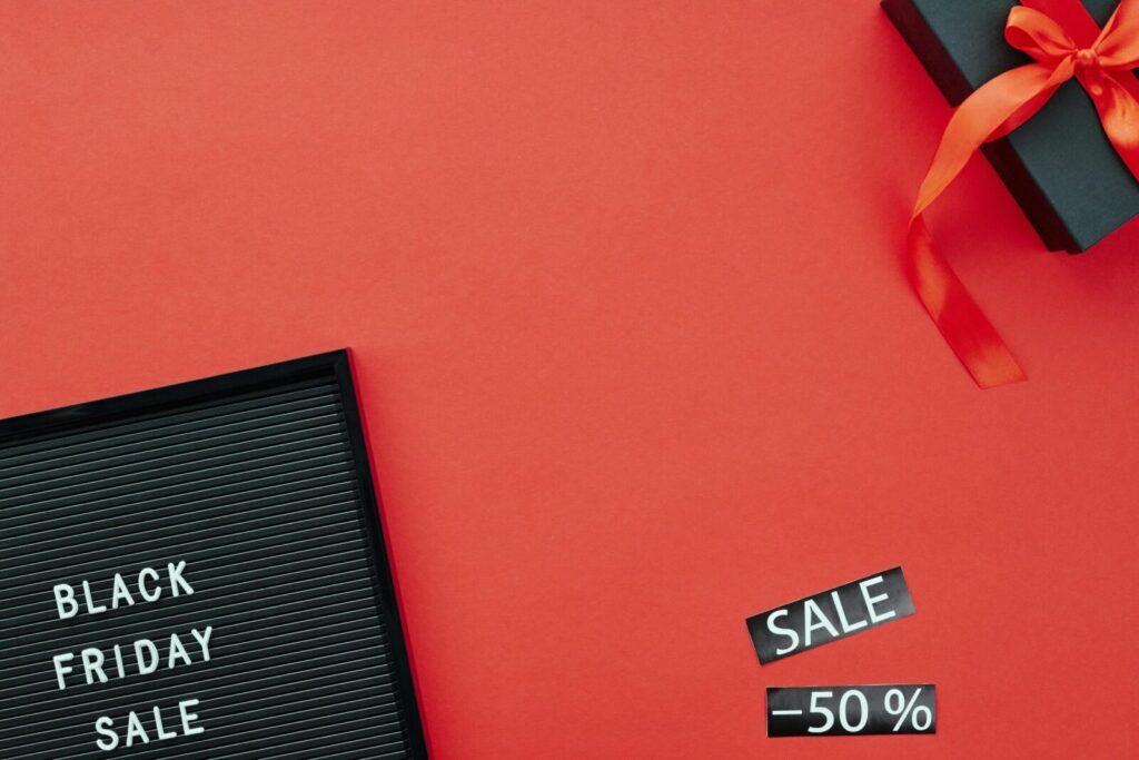 Red background featuring a Black Friday sale sign and gift box, ideal for promoting sales events.
