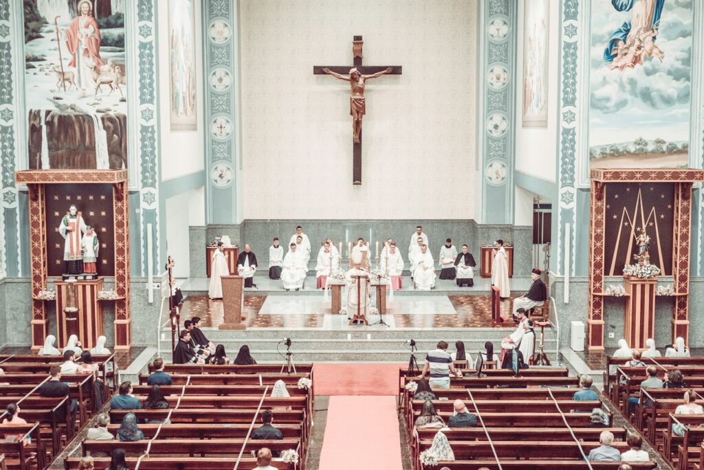 people sitting on red and white chairs inside church