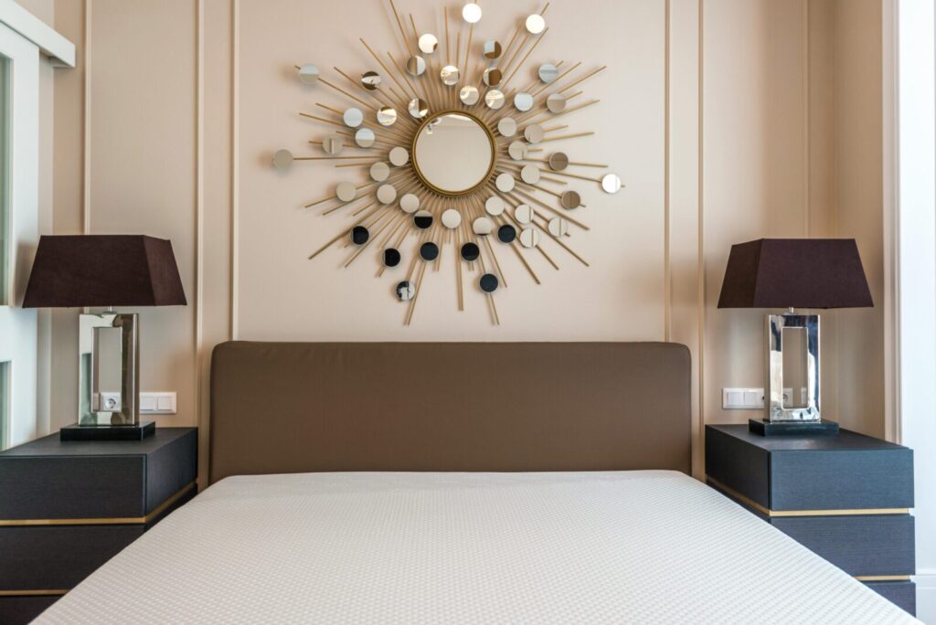 A stylish hotel room featuring a modern bed, elegant wall art, and matching lamps on bedside tables.
