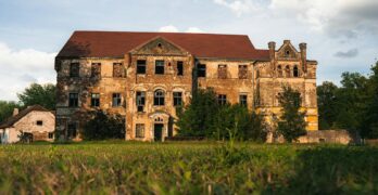 An old abandoned house sitting in a field