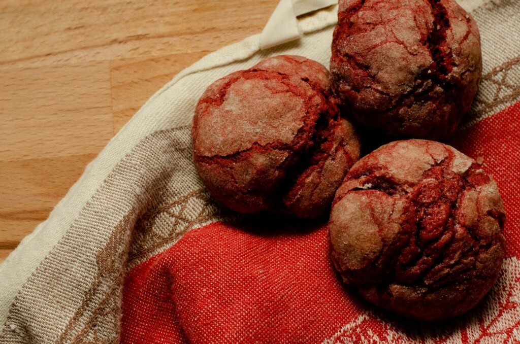 three chocolate muffins sitting on top of a red and white towel
