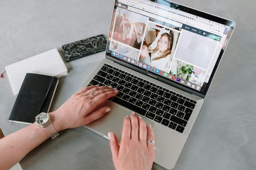 Close-up of a woman browsing online images using a laptop at home, highlighting a creative workspace.