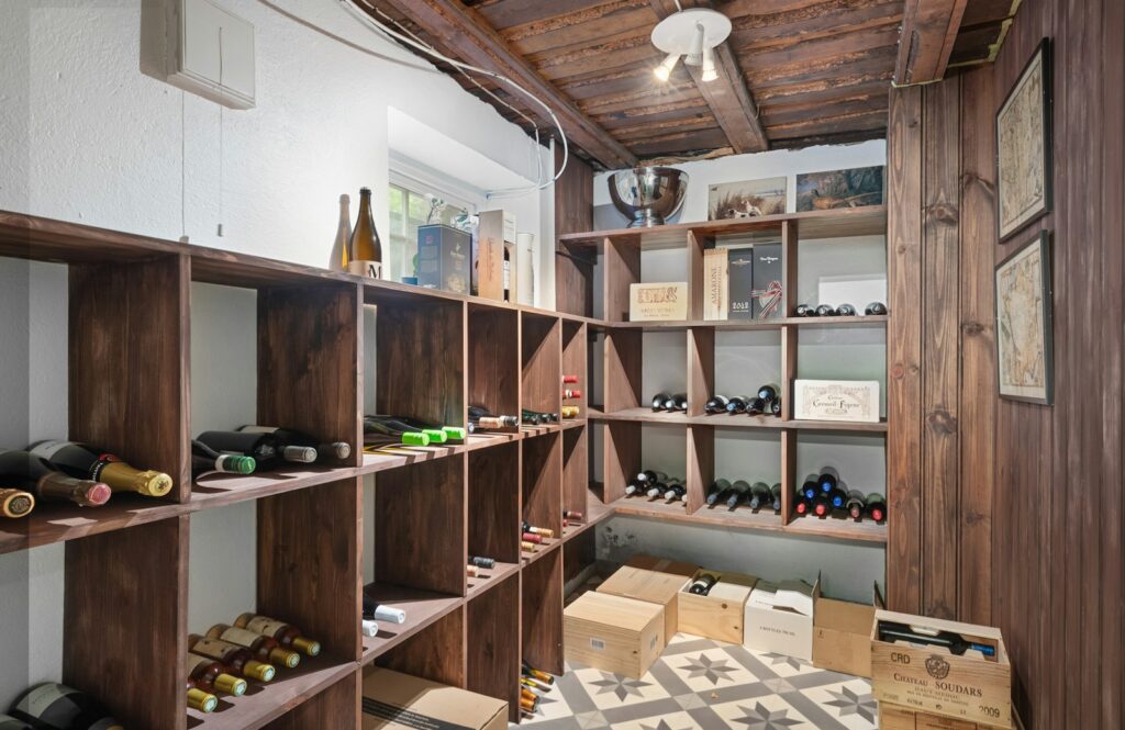 A room filled with lots of wooden shelves filled with bottles