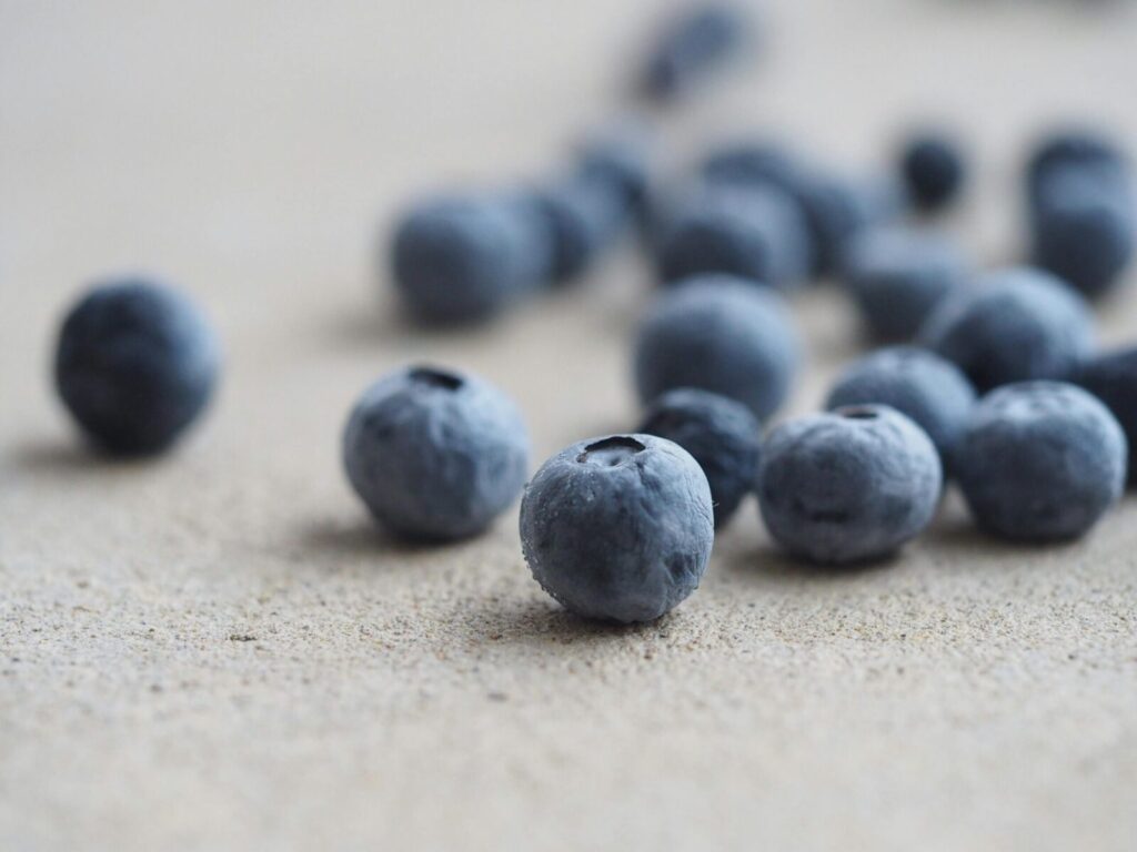 High-quality close-up of blueberries on a light surface, showcasing texture and freshness.