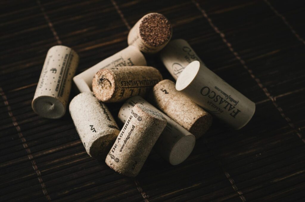 Close-up of various wine bottle corks arranged on a dark wooden surface.