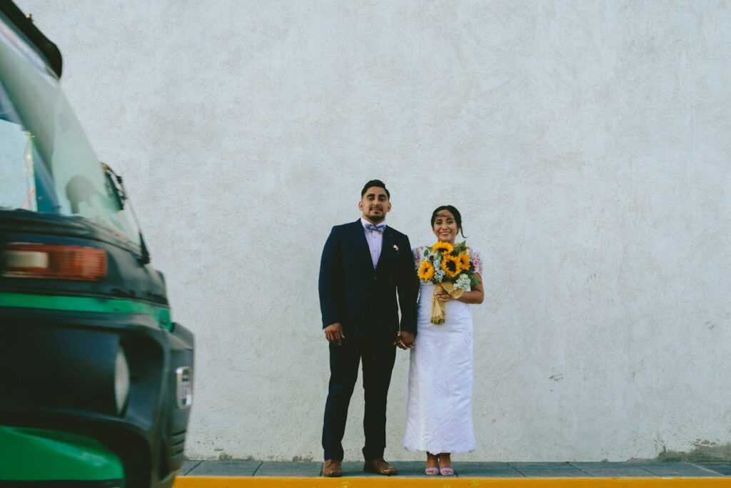 man in black suit standing beside woman in white wedding dress