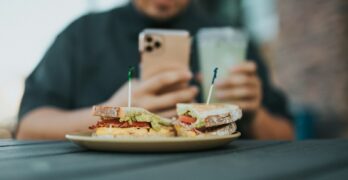 man in gray sweater holding silver iphone 6