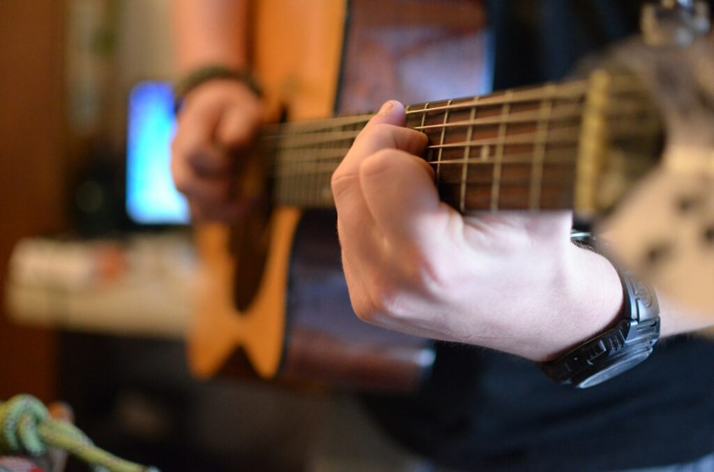 a person playing a guitar in a living room