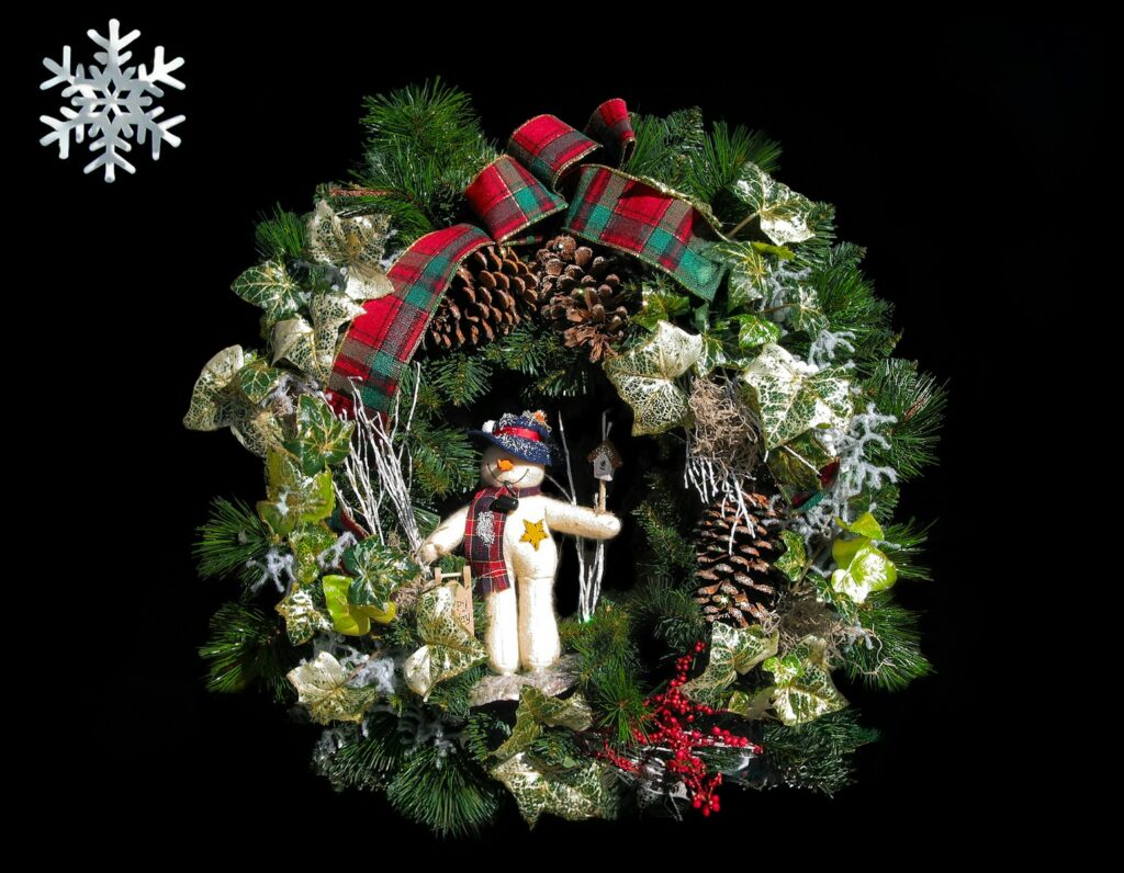 A christmas wreath with a teddy bear and snowflakes