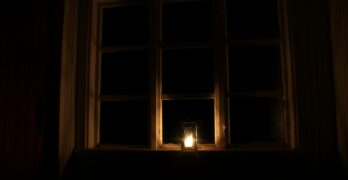 a candle is lit in front of a window