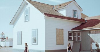 a couple of people standing in front of a house