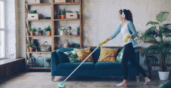 Woman with headphones mopping a wooden floor