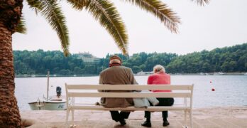 coupe sitting on white bench near body of water