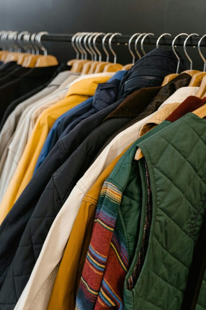 A stylish assortment of jackets and vests neatly hanging in a boutique store display.
