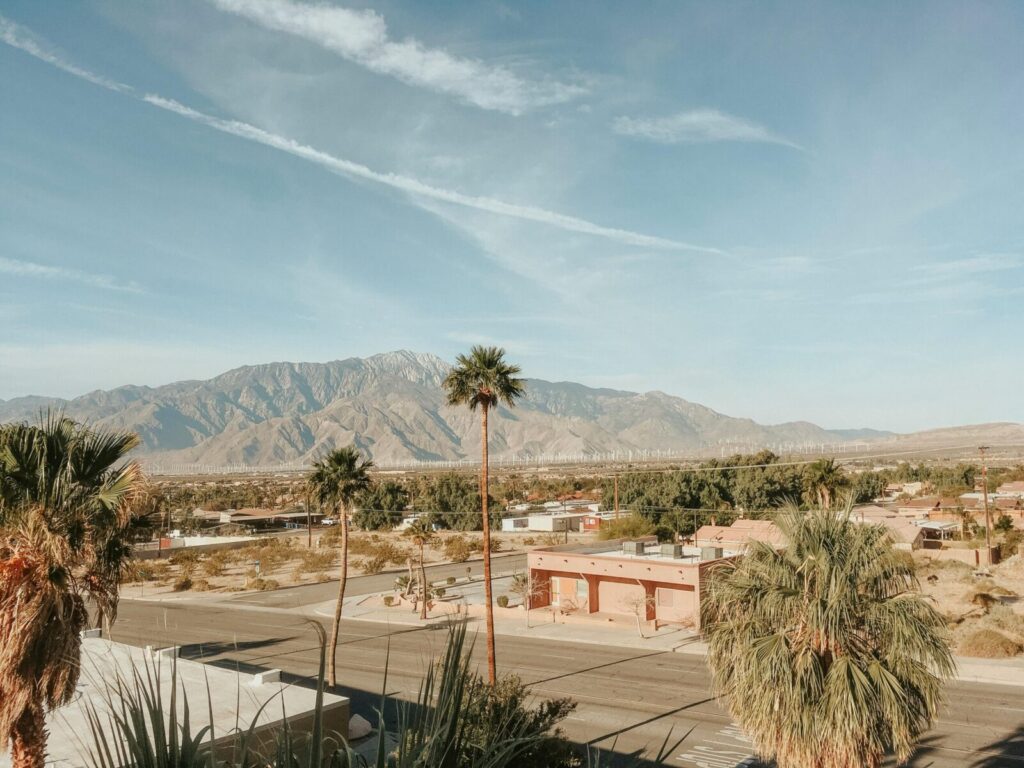 Stunning desert landscape in Palm Springs, CA, featuring mountains, palm trees, and clear skies.