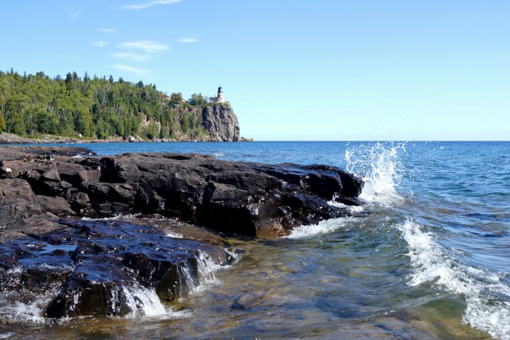 rocky mountain beside body of water during daytime