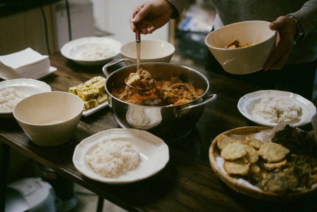 A person standing over a table filled with food