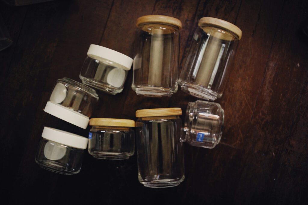 a group of glass jars sitting on top of a wooden table