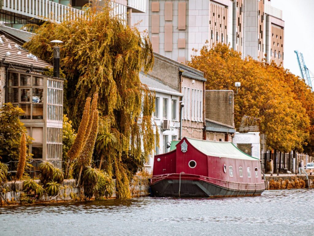 Colorful autumn scene with a houseboat on a calm canal in Dublin, Ireland.