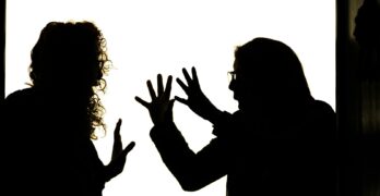 Silhouetted figures engage in a heated argument.