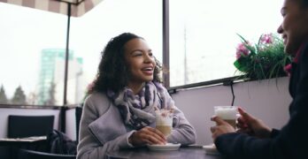 Two people enjoying coffee at an outdoor cafe.