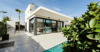 white and grey concrete building near swimming pool under clear sky during daytime