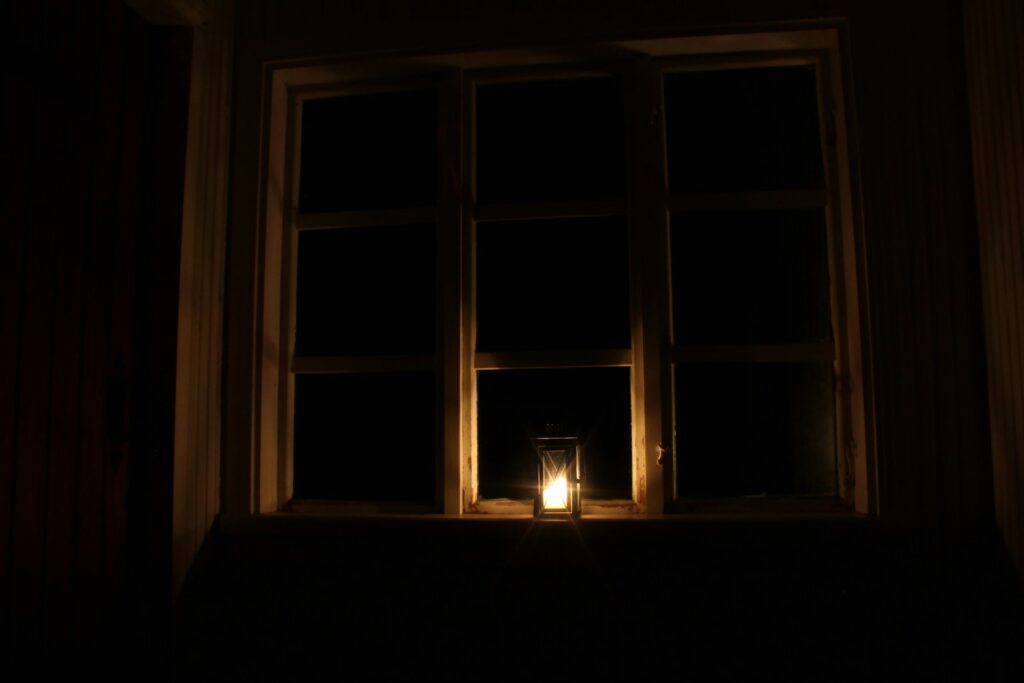 a candle is lit in front of a window