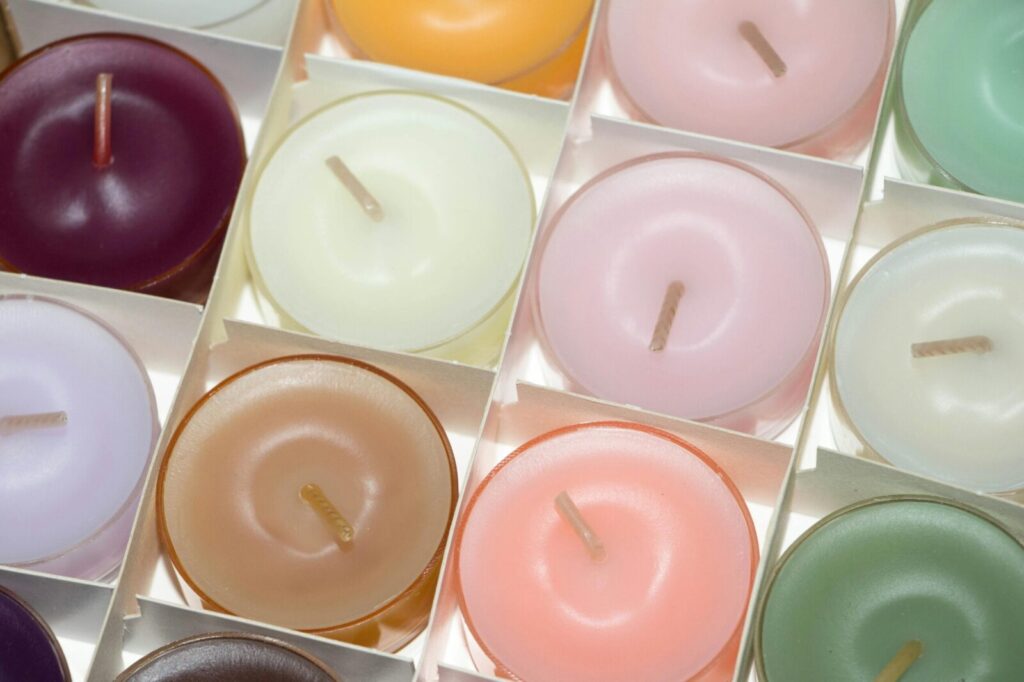 Colorful array of scented tea light candles in a decorative setting.