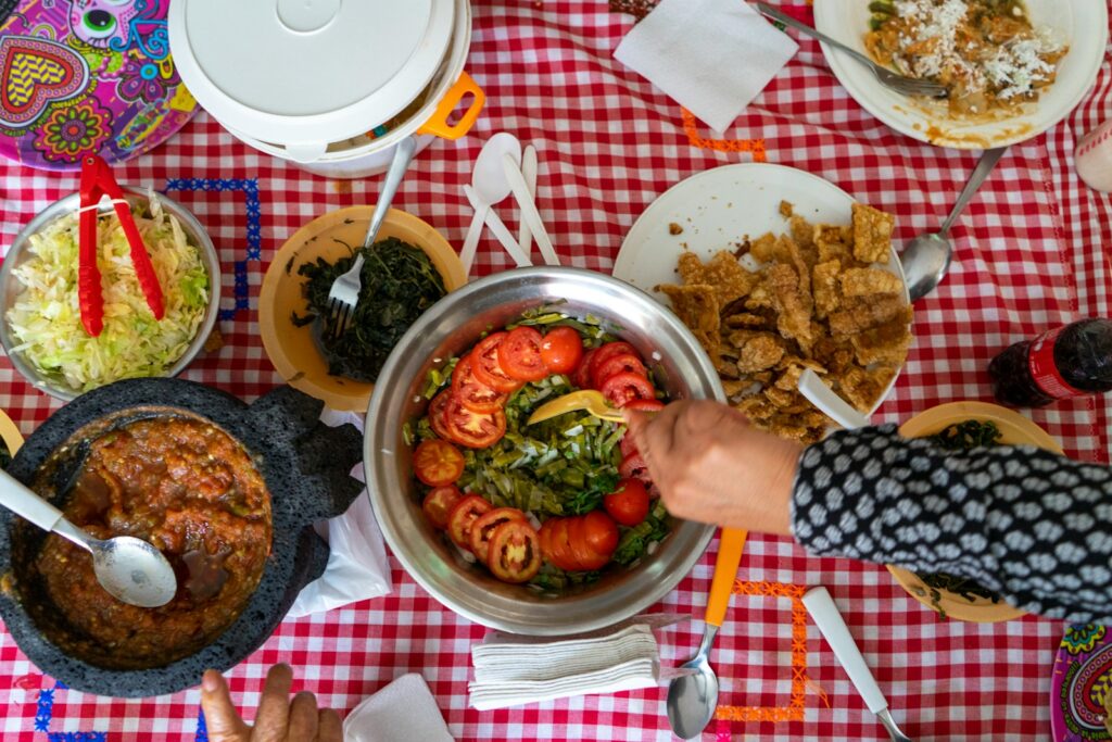 person holding stainless steel bowl with cooked food