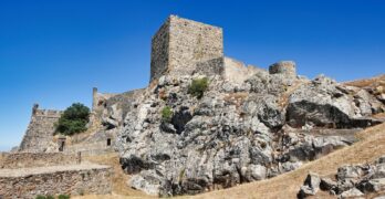 a stone building on a rocky hill