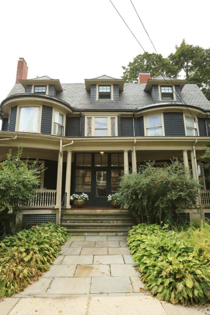 Charming Victorian-style house with lush greenery and classic architectural features.