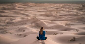 woman sitting on sand field