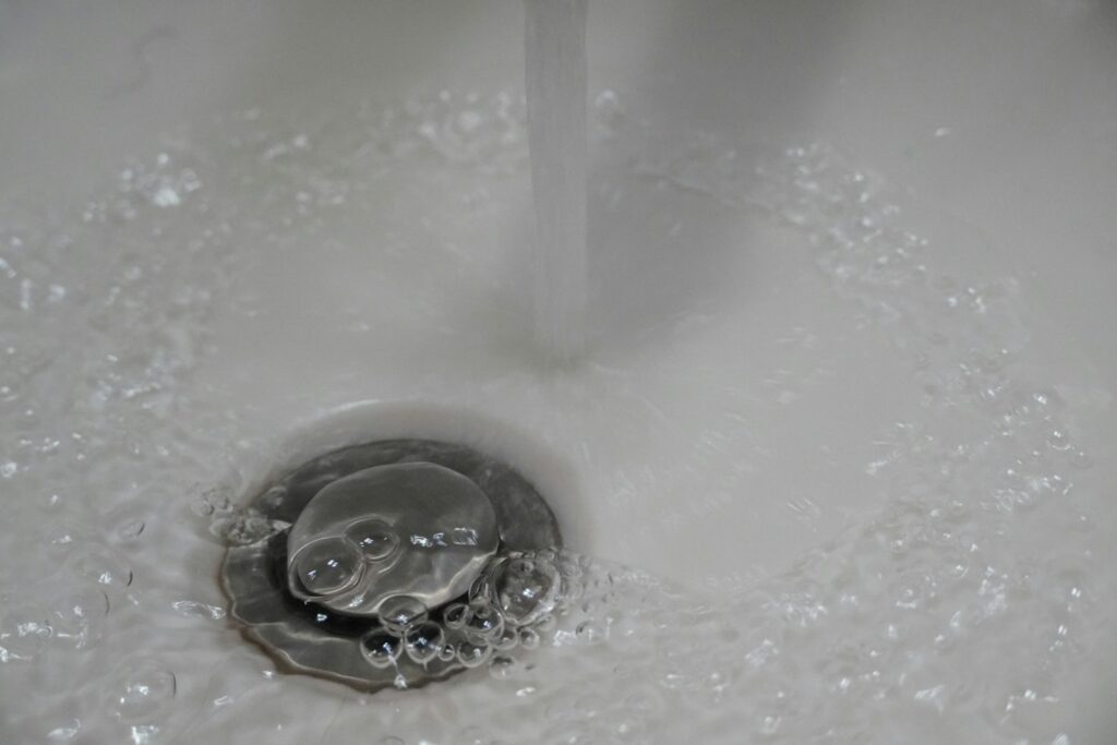 a close up of a sink with water running down it