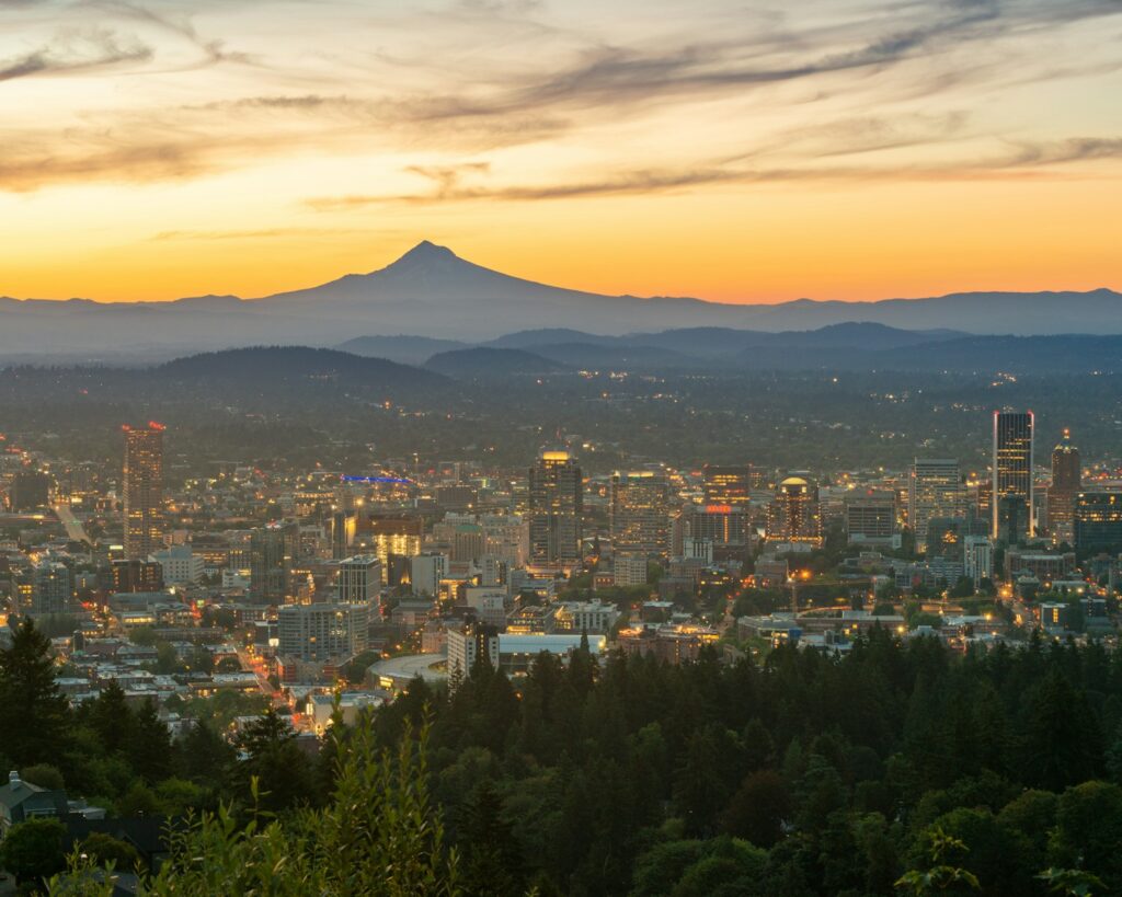 city with high rise buildings near mountain during sunset