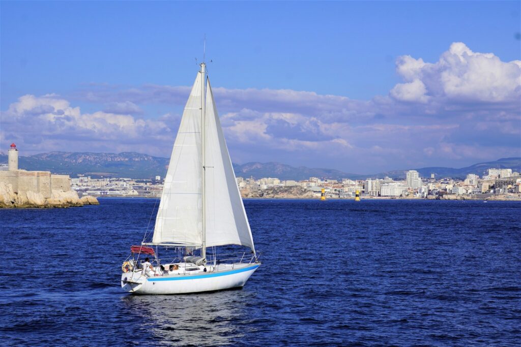 a sailboat in the water with a city in the background