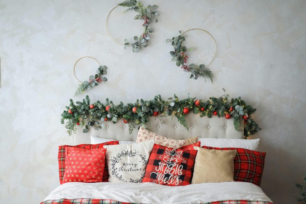 Festive Christmas bedroom with decorated headboard and cozy, themed pillows creating a warm holiday ambiance.