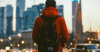 a man with a backpack is standing on the street