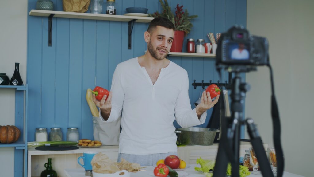 Man holding tomatoes in a kitchen