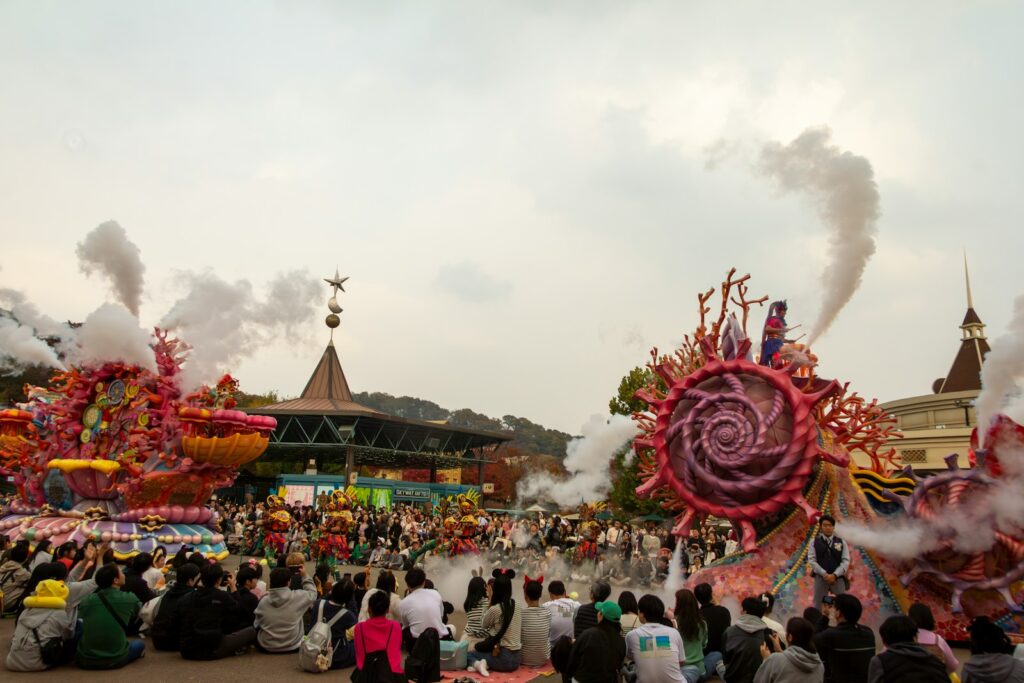 a group of people sitting on the ground watching a parade