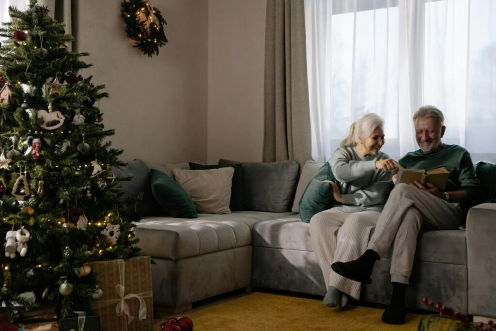 Elderly couple enjoying a peaceful Christmas moment together by the tree.