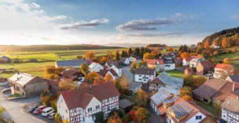 Charming aerial view of a rural village in autumn with vivid colors and clear skies.