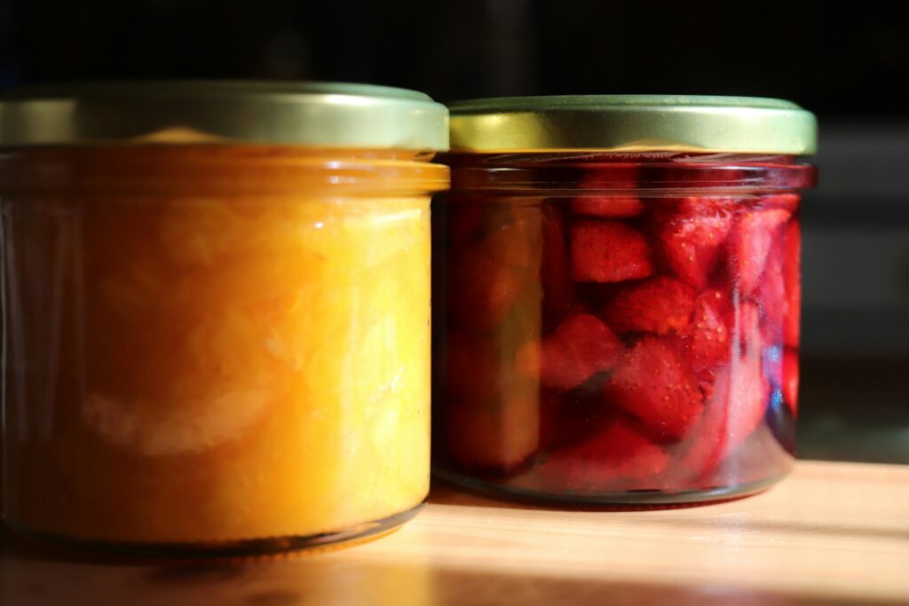 Three jars of pickled fruit sit on a counter