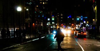 A person walking down a street at night