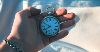 A person holding a pocket watch in their hand
