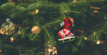 Close-up of a decorated Christmas tree with ornaments and warm lights.