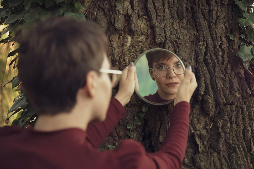 woman in red sweater holding magnifying glass